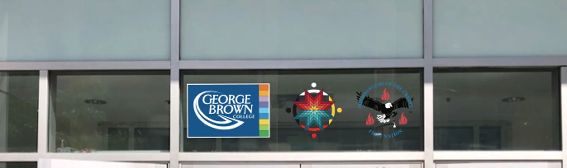 The crest of the Mississaugas of the Credit First Nation, along with the medallion of our Indigenous Initiatives team, proudly displayed next to the George Brown Polytechnic logo above a campus doorway.