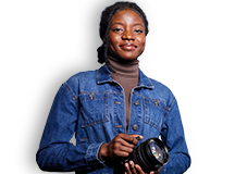 Student in denim jacket holding a camera