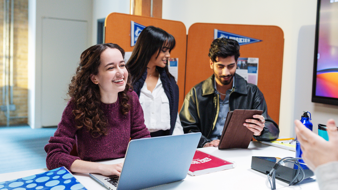 Markeing students smiling and laughing in a classroom