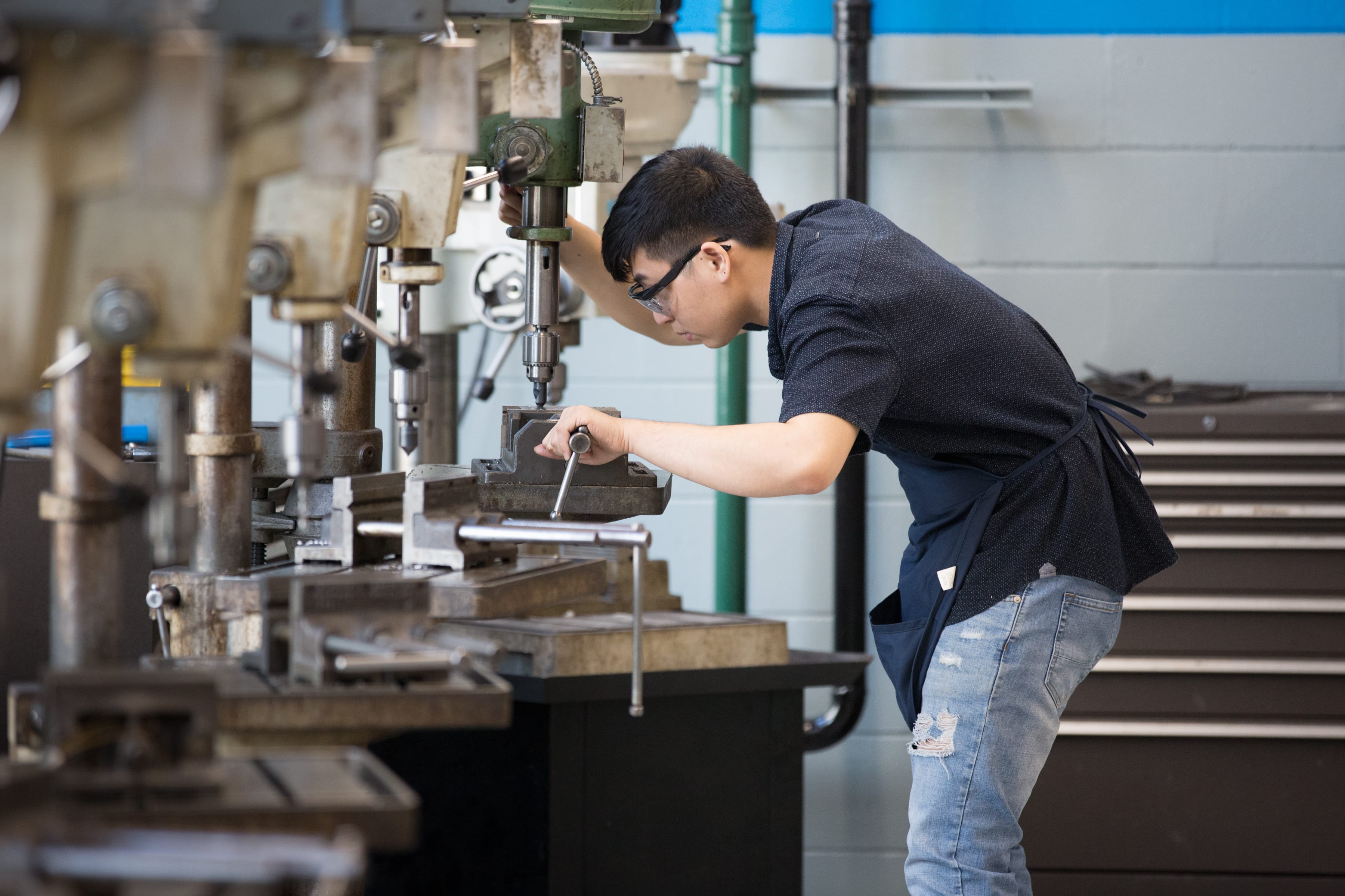 Mechanical engineering student working on a machine in the lab. 