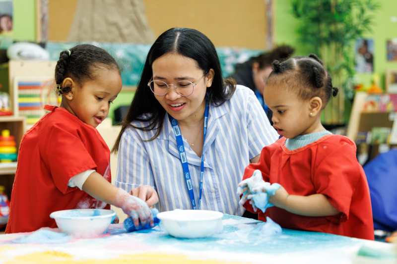 ECE student in with two toddlers making art