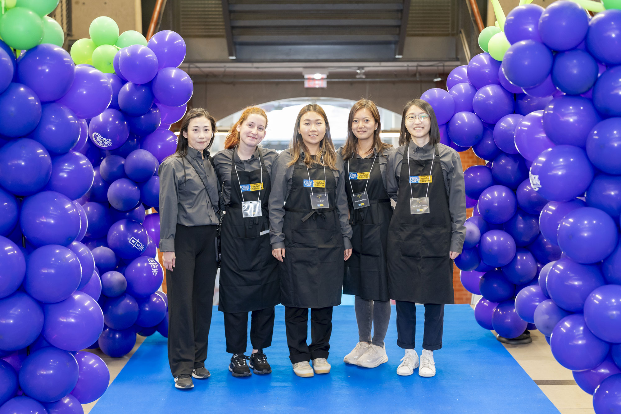 Students at the Rootstock symposium standing in front of purple grape shaped balloons