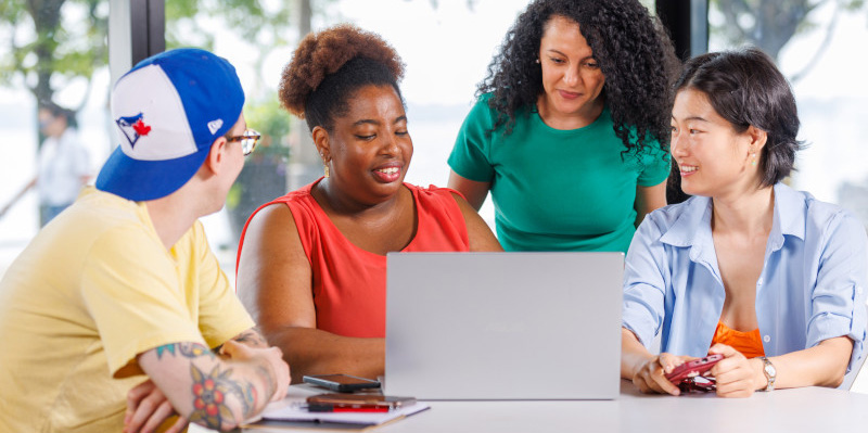 students sitting around a laptop at a table