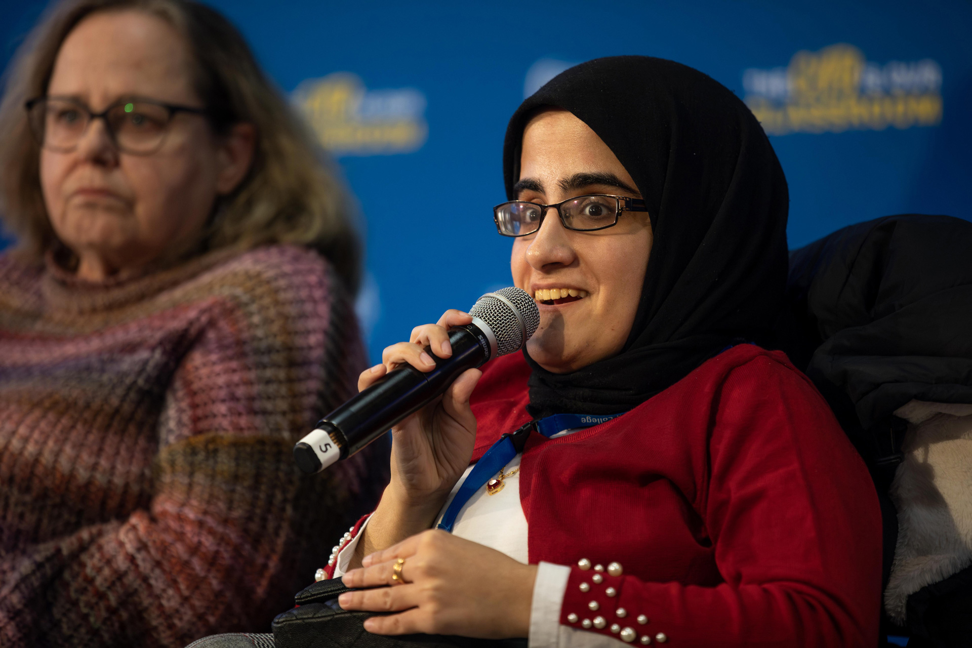 Seated women speaks into a microphone