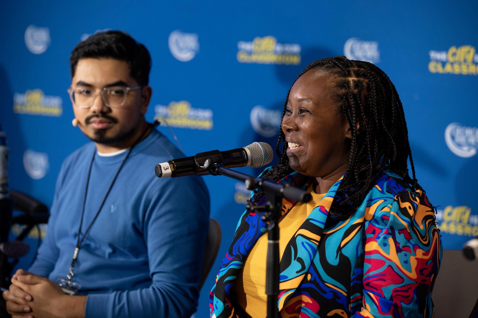 A smiling student speaks into a microphone