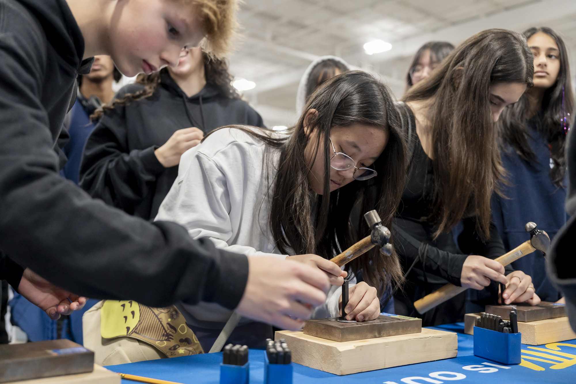 Group of young students hammering metal coins