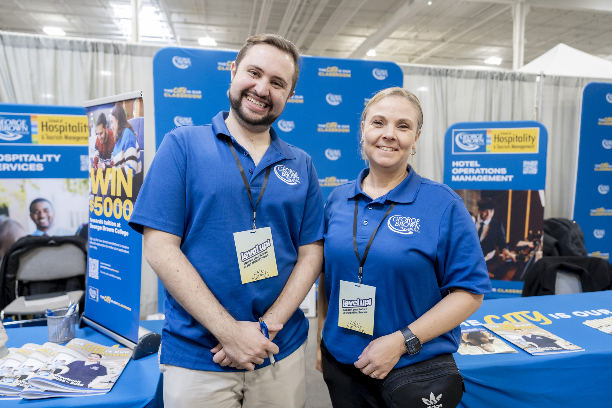 Two people in blue shirts smiling