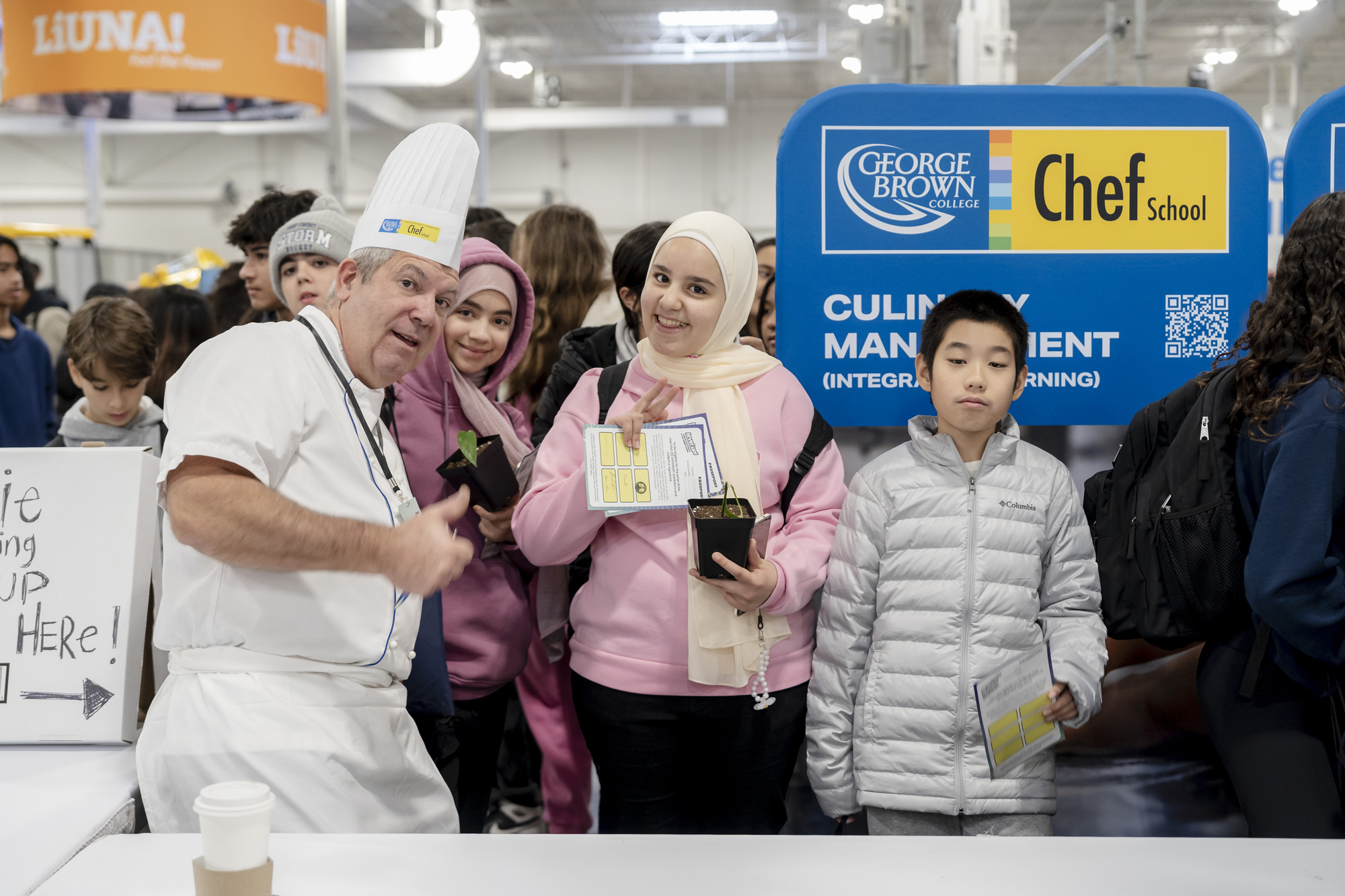 Chef with thumbs up and group of young students