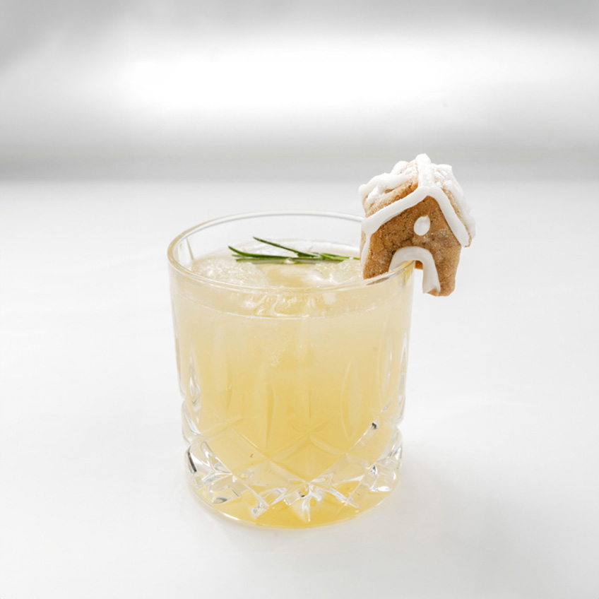 Cocktail with a miniature gingerbread house decoration