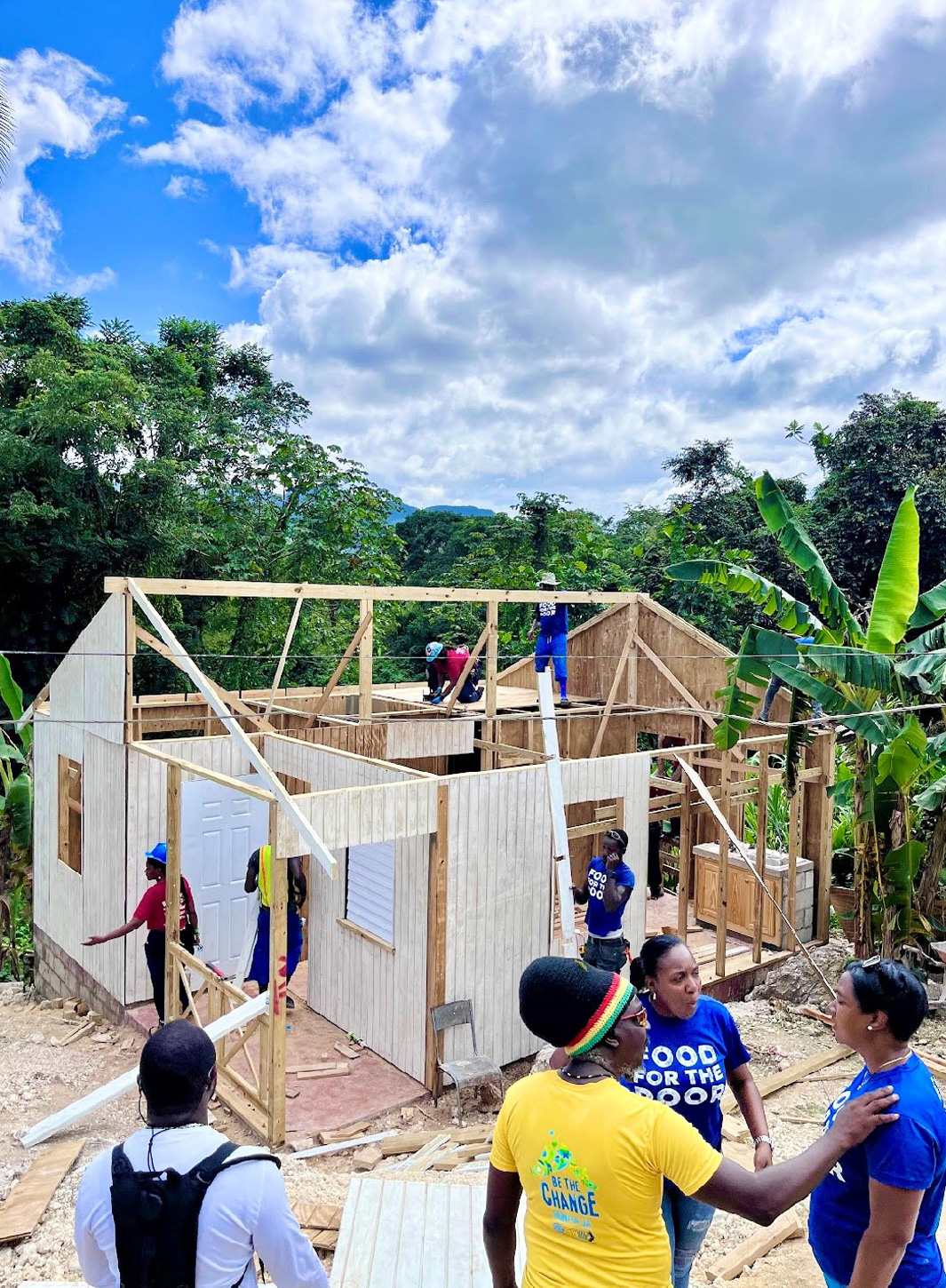 Exterior view of a partially built building in Jamaica with a group of volunteers 