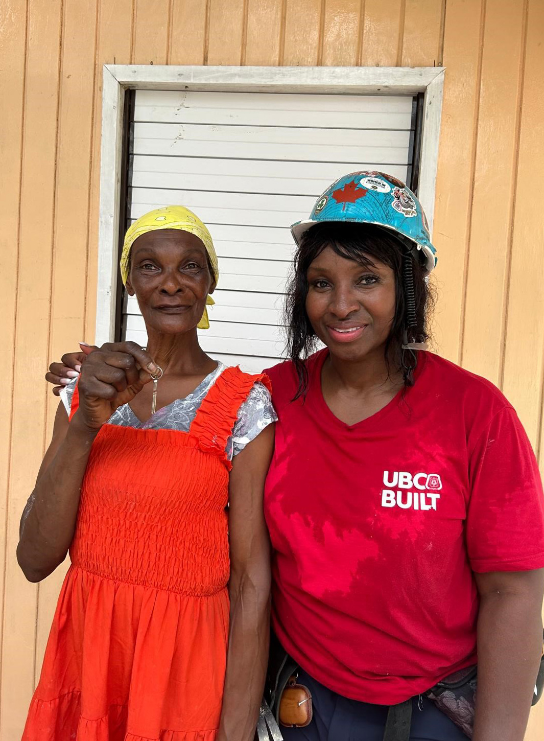 Rok Gueye stands with new homeowner Beulah who has the keys in her hand