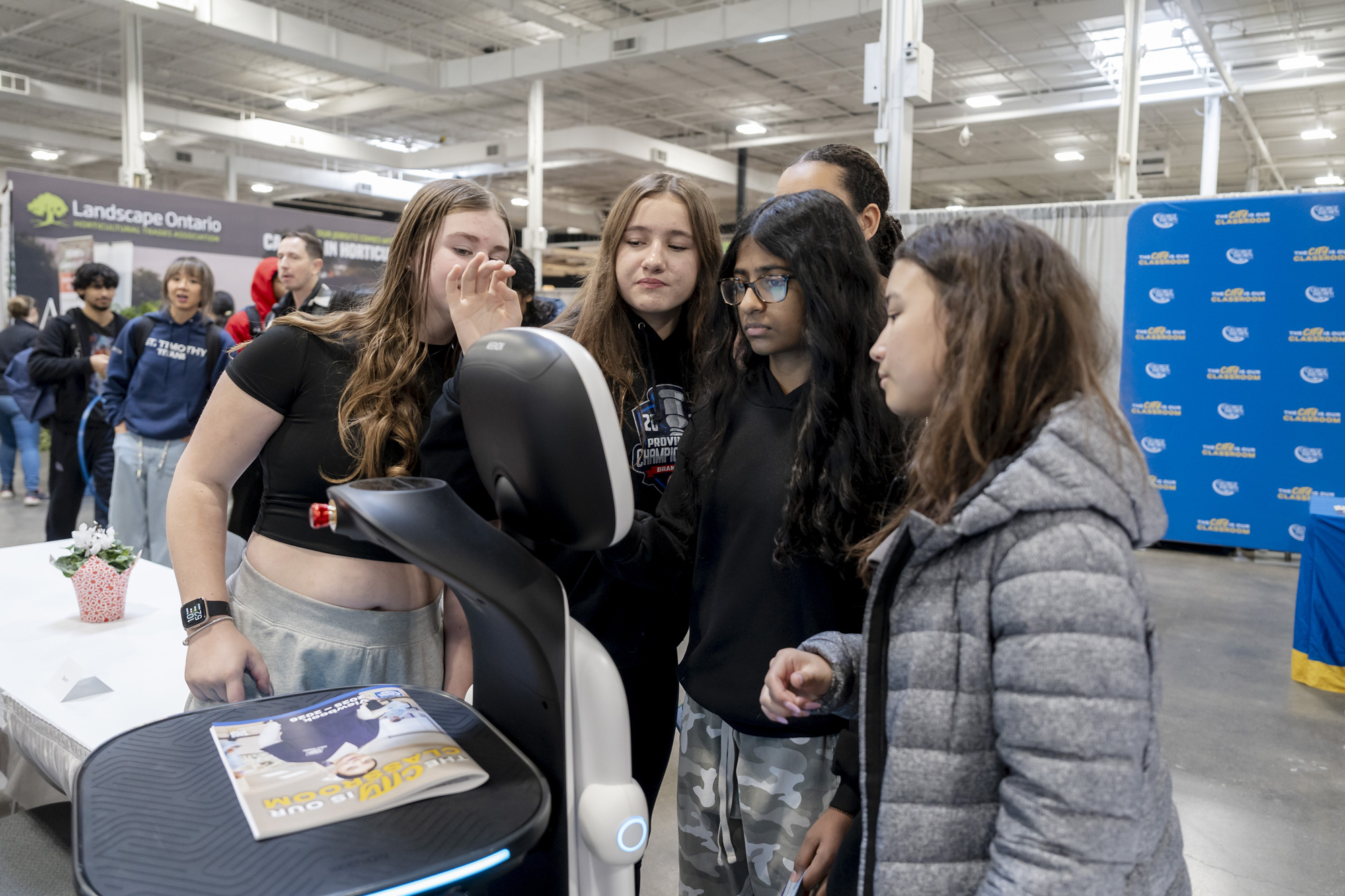 A group of students interact with a robot