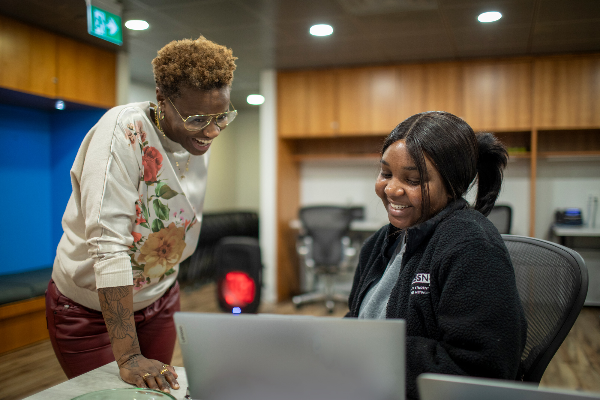 A staff and student chat in the Black Student Success Network's office