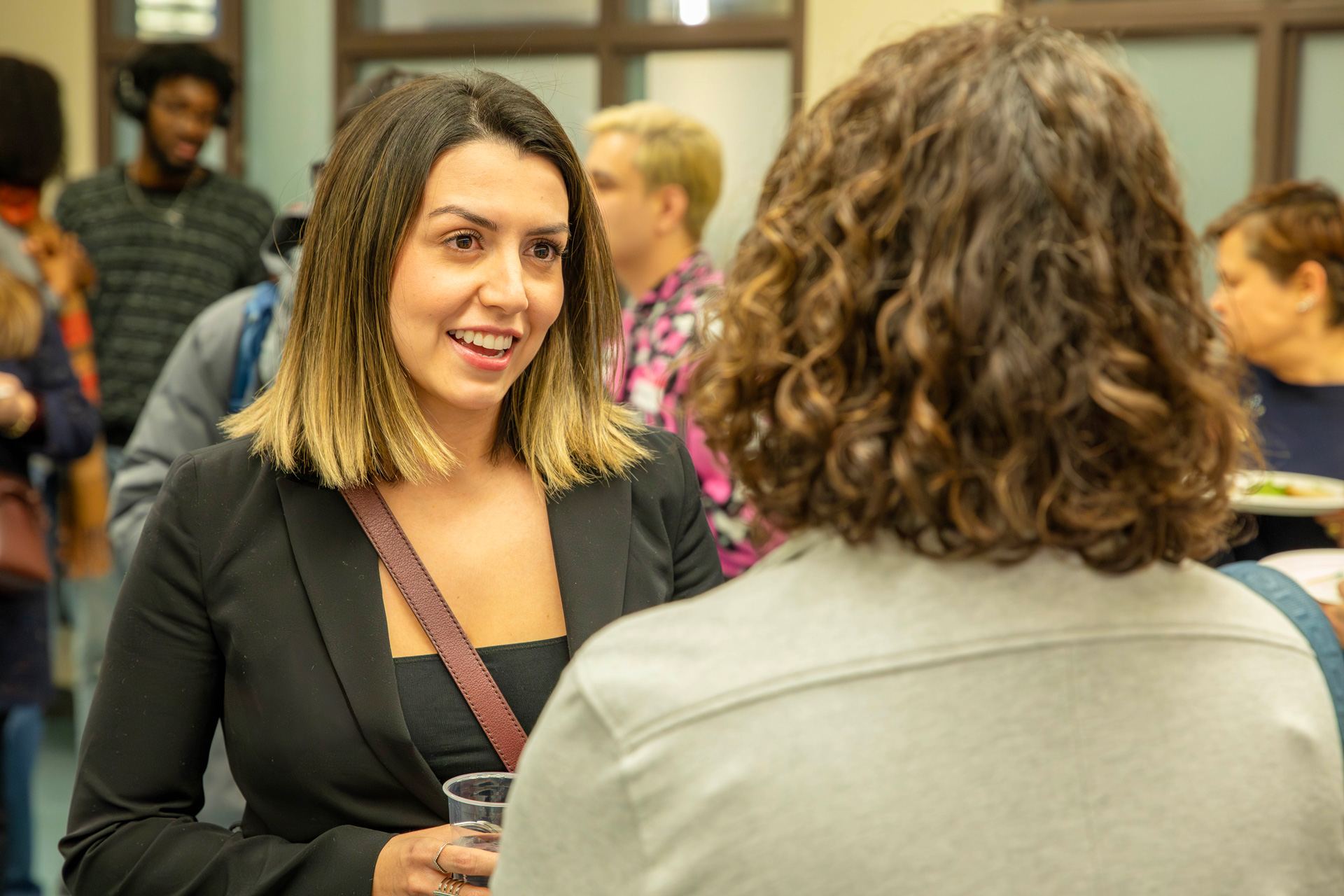 A woman engages in conversation with another woman at the alumni chapter launch