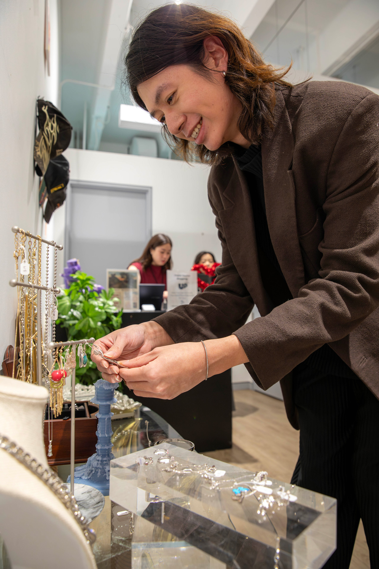 A man leans over a display of jewellery in the fashion shop at GBC