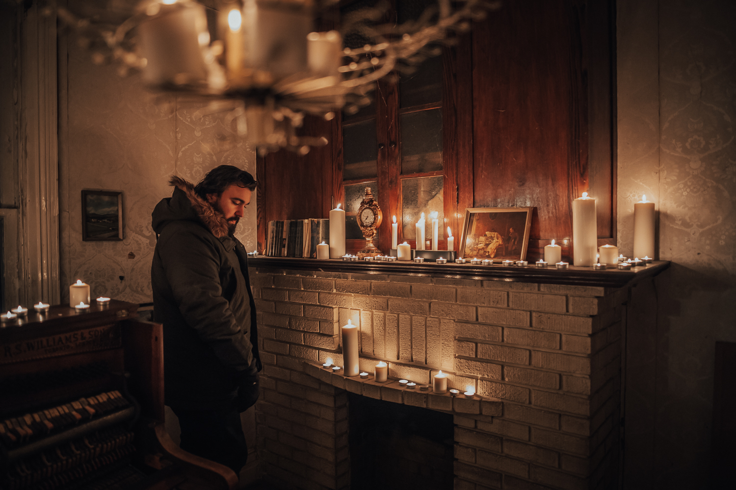 Mitchell LeBlanc on set in a dark room with candles