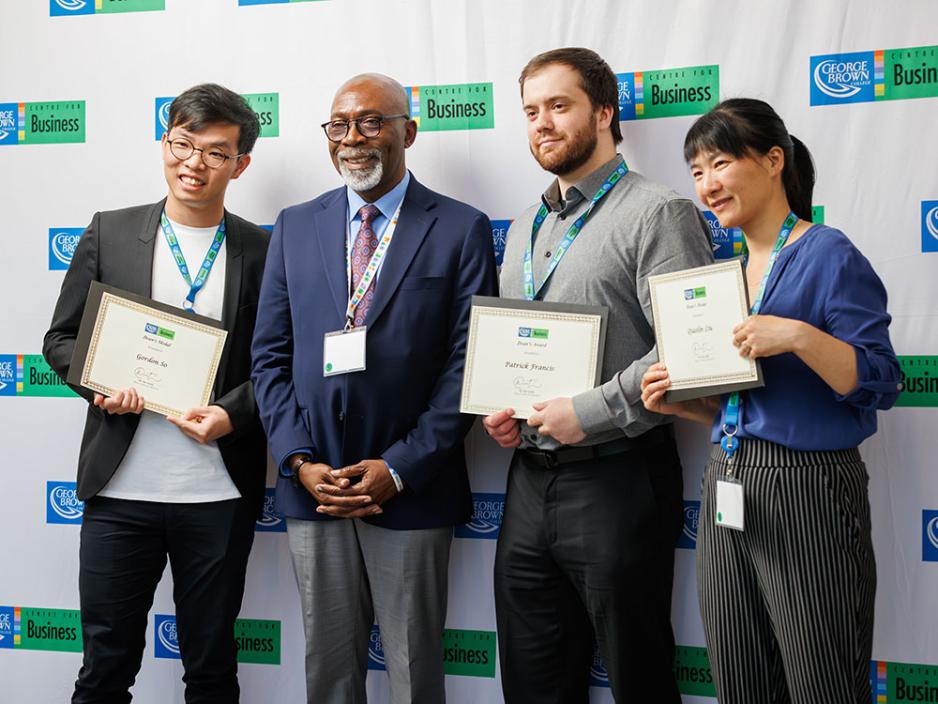 3 student award winners holding certificates with Centre for Business Dean Dr. Ian Austin